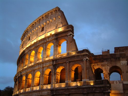 Detail of arches of Colosseum at night in Rome.