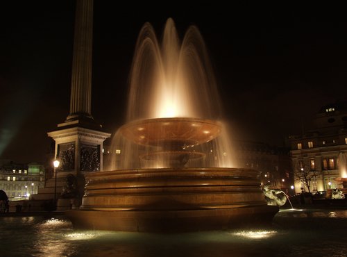 View of Trafalgar Square at night in London.