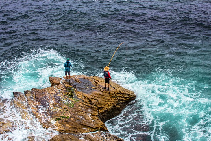 Two fisherman on the rocks at Bondi Beach