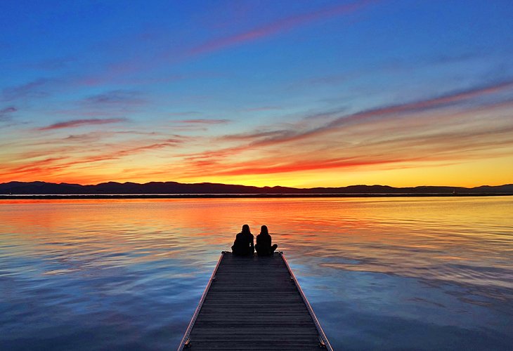 A couple enjoying sunset on Lake Champlain