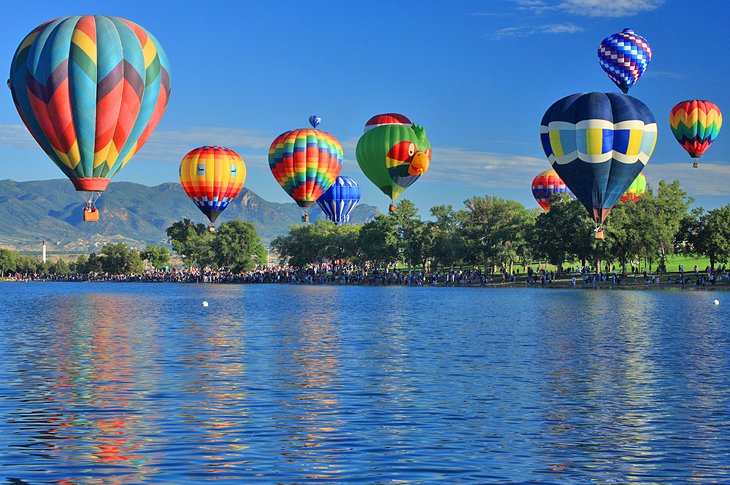 Hot air balloons launching over a lake in Colorado Springs