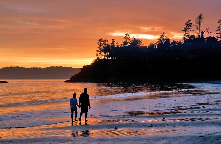 Couple walking on the beach at sunset in Tofino, B.C.