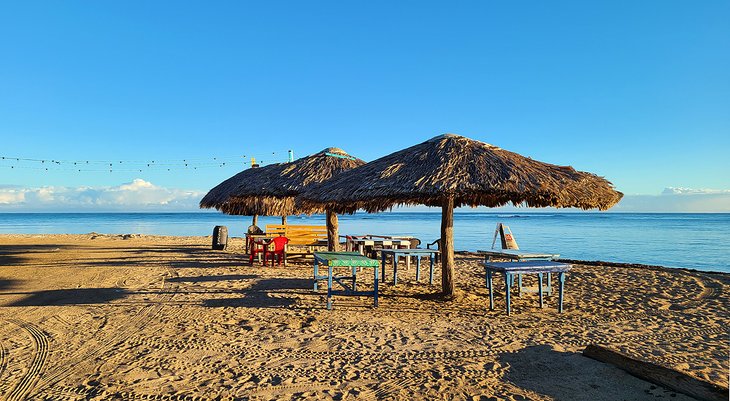 Palapas and tables on the beach in Buen Hombre