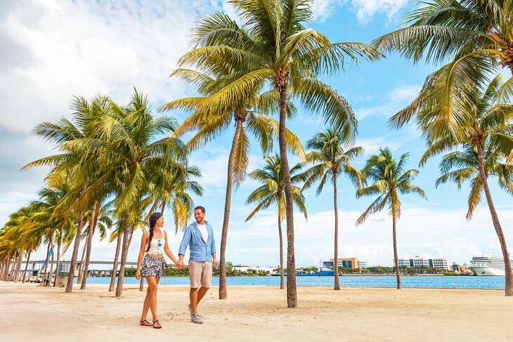 Couple walking under palms in Miami, Florida