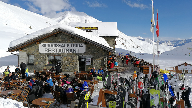 Skiers relax, dine and drink on the terrace of a mountainside restaurant in Ischgl, Austria