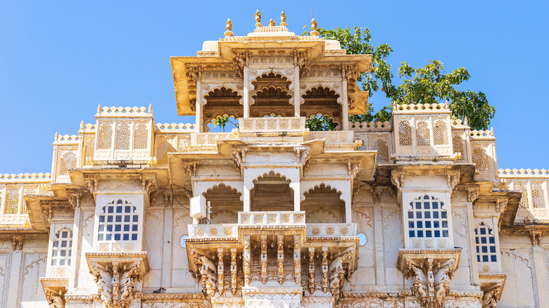 View of ornate gold and white balconies on a sunny day at the City Palace in Udaipur, India