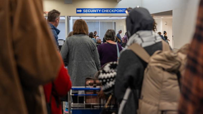 Airline passengers wait in line for the security checkpoint at at an airport