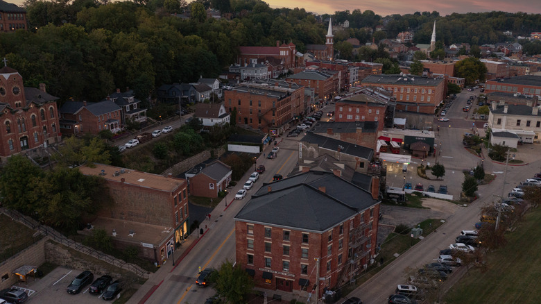 A drone view of downtown Galena, IL at dusk in the summertime showcasing all of the historic buildings and streets.