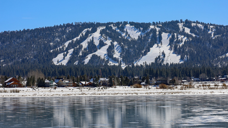 iew across the Big Bear Lake of cabins and the Snow Summit Ski Resort snow covered mountains on the background.