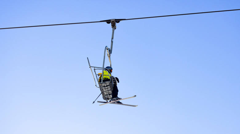 Snowboarders riding lift over San Bernardino Mountains, California on January 13 2026 against a blue ski