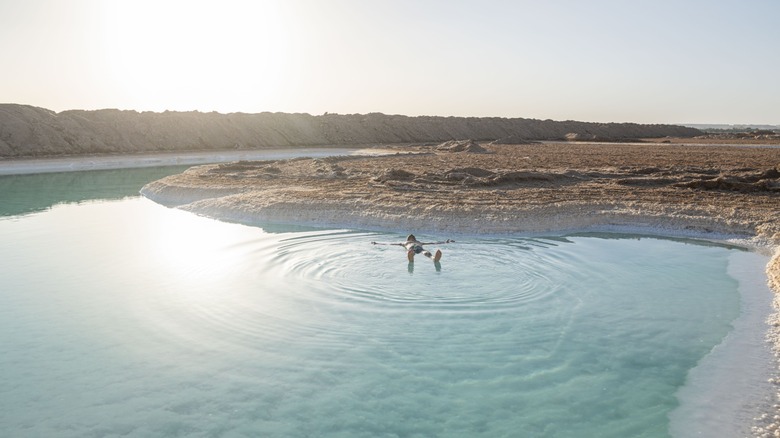 Solo tourist floating in a salt lake at Siwa Oasis, Egypt