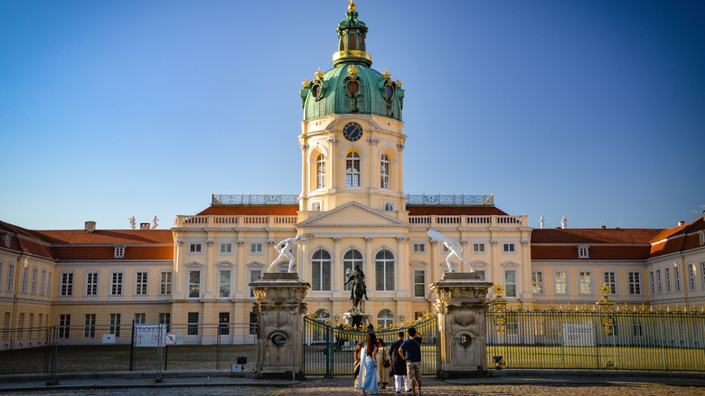 Tourists look up at the facade of Charlottenburg Palace, Berlin