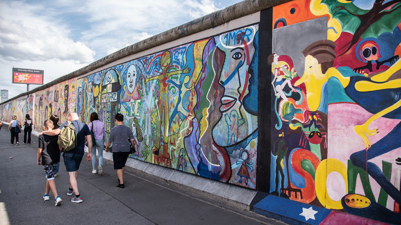 Tourists walk along the East Side Gallery segment of the Berlin Wall