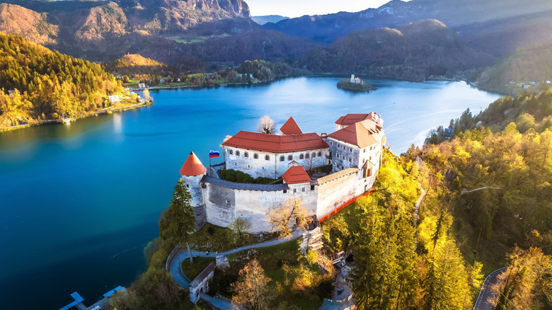 Aerial view of Bled Castle perched on a cliff above scenic lake aerial view, mountain landscape of Slovenia
