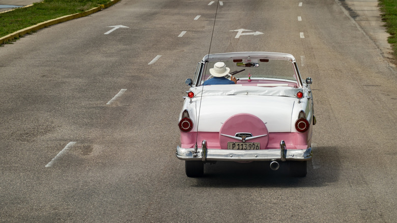 Rear view of Ford Fairlane Convertible from 1950s, dual tone pink-white vintage vehicle
