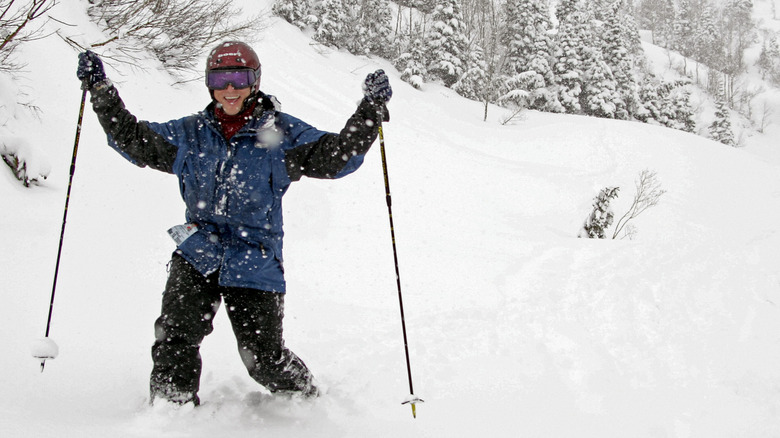 A smiling skier stands in the snow at Alta Ski Area, Utah