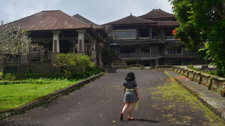 Traveler walking into ruins of the Bedugul Taman Rekreasi Hotel in Bali