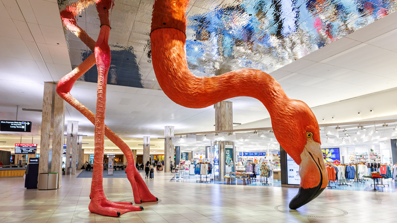 A giant pink flamingo art installation in a terminal lobby at Tampa International Airport.