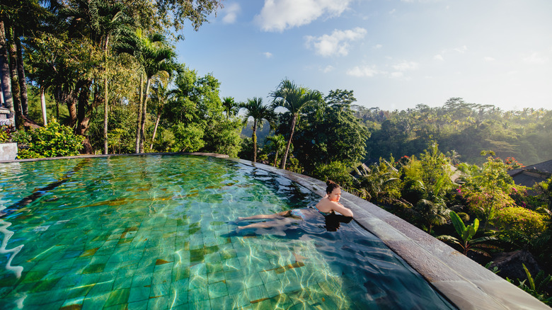 woman in a pool overlooking tropical forest