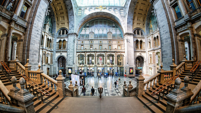 An elevated wide-angle view of the stone hall and staircases inside Antwerp Central Station