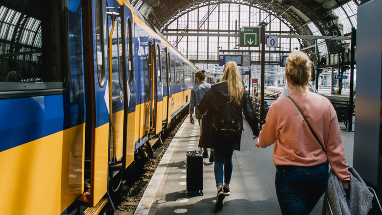 Tourists heading to a train inside of Amsterdam Centraal station