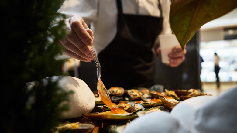 waiter adding sauce to a plate