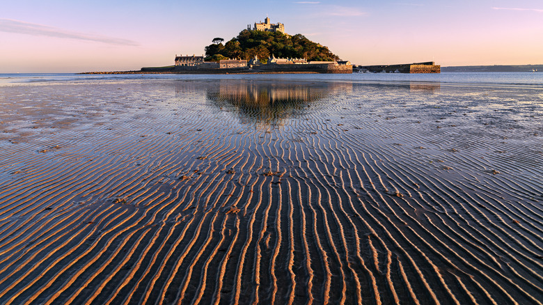 mount saint michel in the distance with sand in foreground signifying low tide