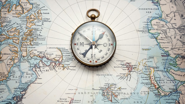 a magnetic compas sits on top of a map of the world