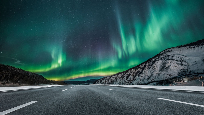 aurora borealis over asphalt road