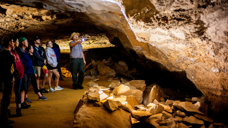 a group of visitors inside a dark but lit cave at Mammoth Cave National Park