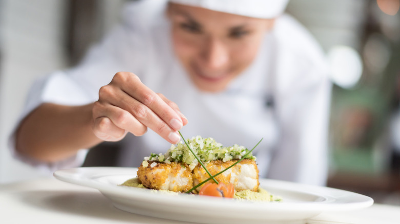 a chef deocrating a plate of food