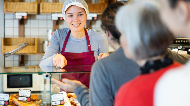 a sales person taking someone's order at a bakery