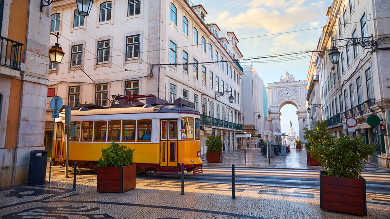 A tram passes by the triumphal arch at Rua Augusta in Lisbon