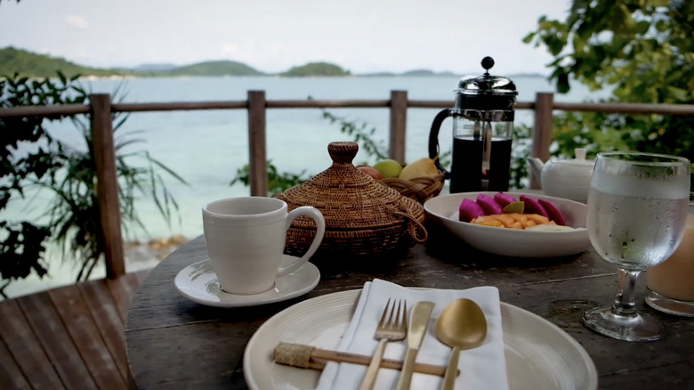 A table with food and coffee overlooking Indonesian islands at Cempedak Private Island