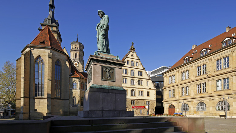 A sculpture of Friedrich Schiller with the Stiftskirche in the background
