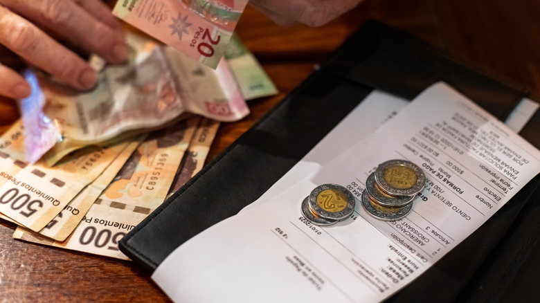 A customer pays a restaurant bill in Mexican pesos.