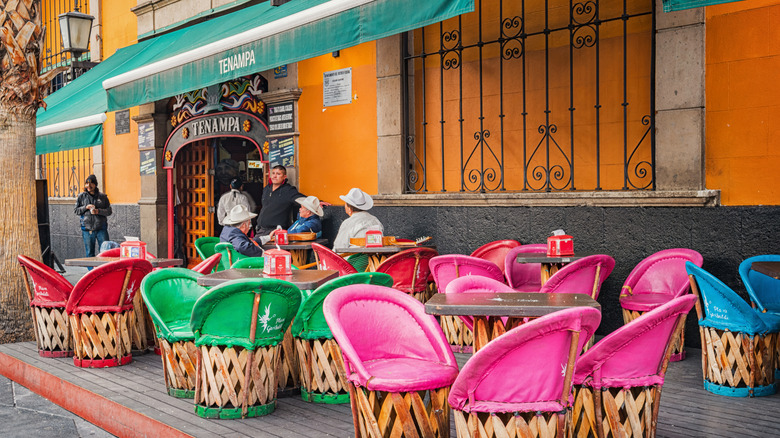 A restaurant terrace in Mexico City with colorful chairs