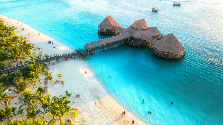 Traditional beach bungalow over the water along the sandy beaches of Zanzibar, Tanzania