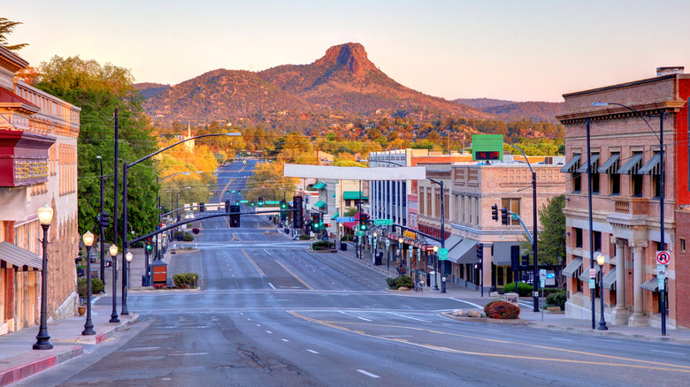 Main road in Prescott, Arizona, lined by low-rise historic buildings with a mountain in the background.