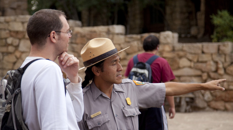 A ranger speaks to a visitor at Grand Canyon National Park outside of a visitor center.