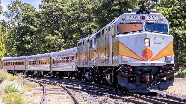 Head-on view of the yellow and silver historic Grand Canyon Railway Train traversing the landscape