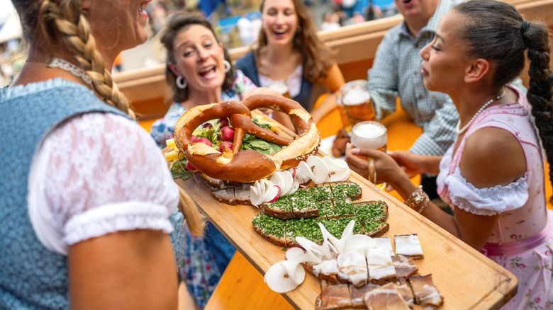 A waitress carrying a platter of assorted foods in a beer garden