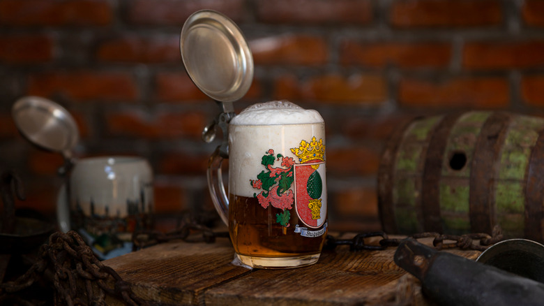 A traditional german beer stein made of ceramic with a painted design and lid