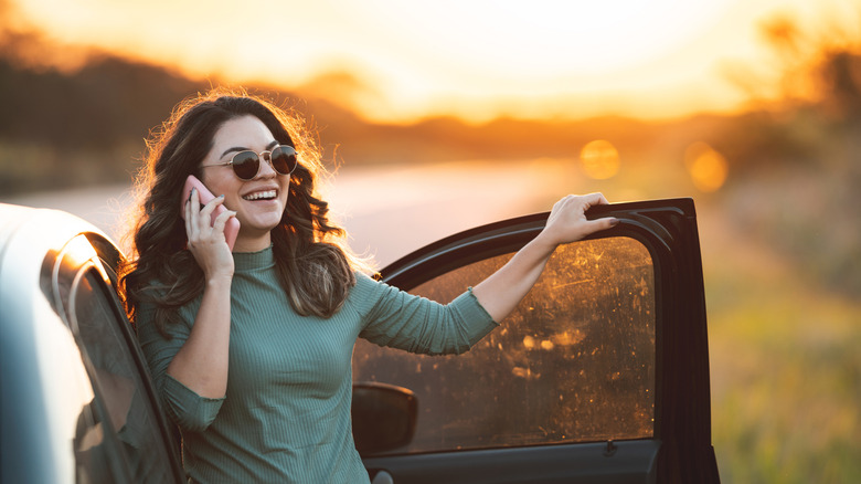 A smiling woman talking on the telephone at sunset