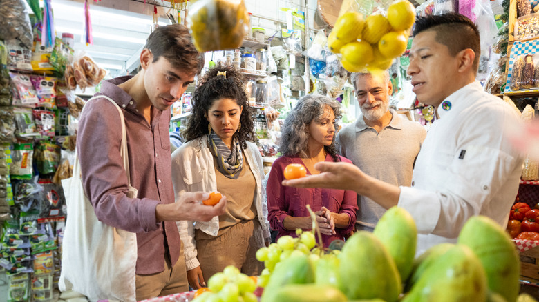 A chef leading a group of travelers on a food tour