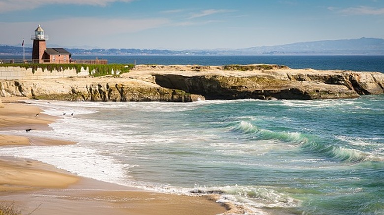 view of the historic lighthouse and museum across a sandy beach