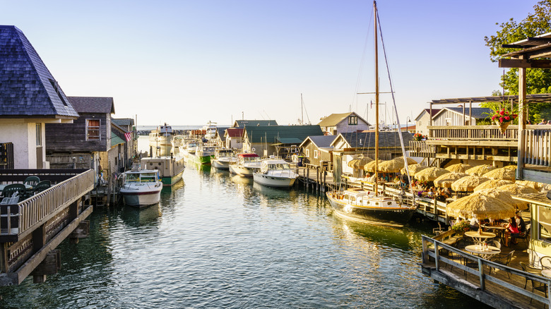 Marina of Fishtown, lined with boats, shingled buildings and umbrellas, leading to Lake Michigan in Leland, Michigan