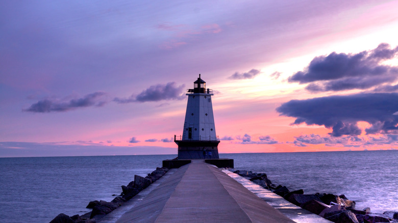 Historic lighthouse during a purple and pink sunset along the shores of Lake Michigan in Ludington State Park