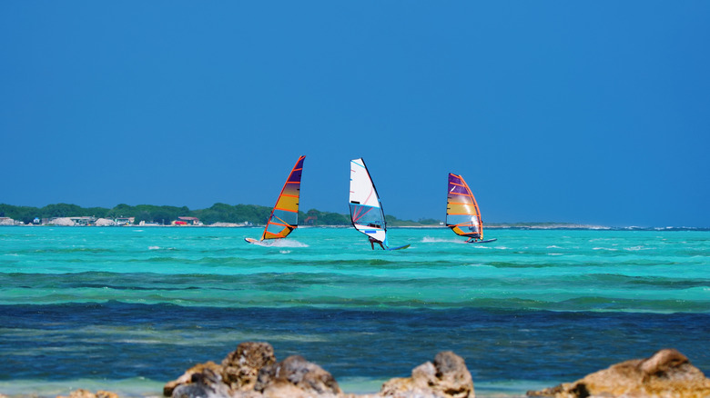 Three windsurfers in turquoise water