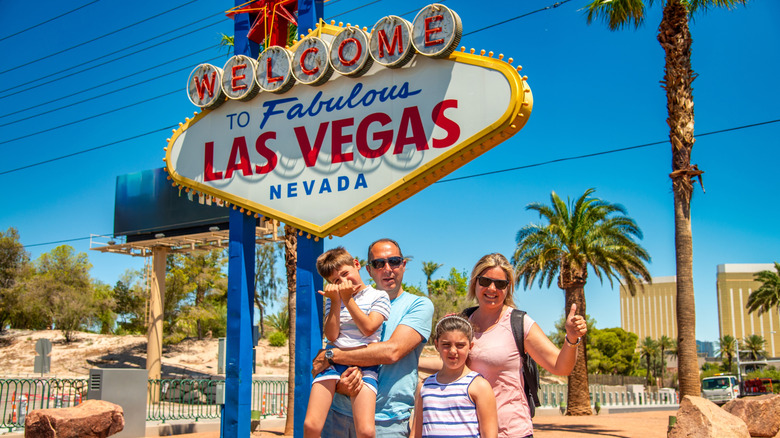 A family poses in front of the Las Vegas sign